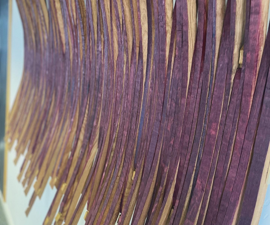 a close up of the red wine staining on a burgundy wine barrel art sculpture